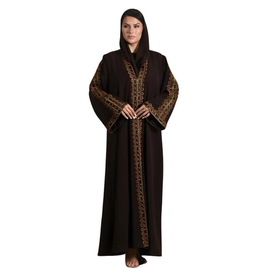 Woman wearing a long dark brown abaya with gold embroidery on a white background