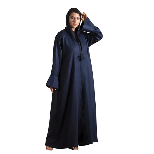 Woman wearing a navy blue abaya with a white background