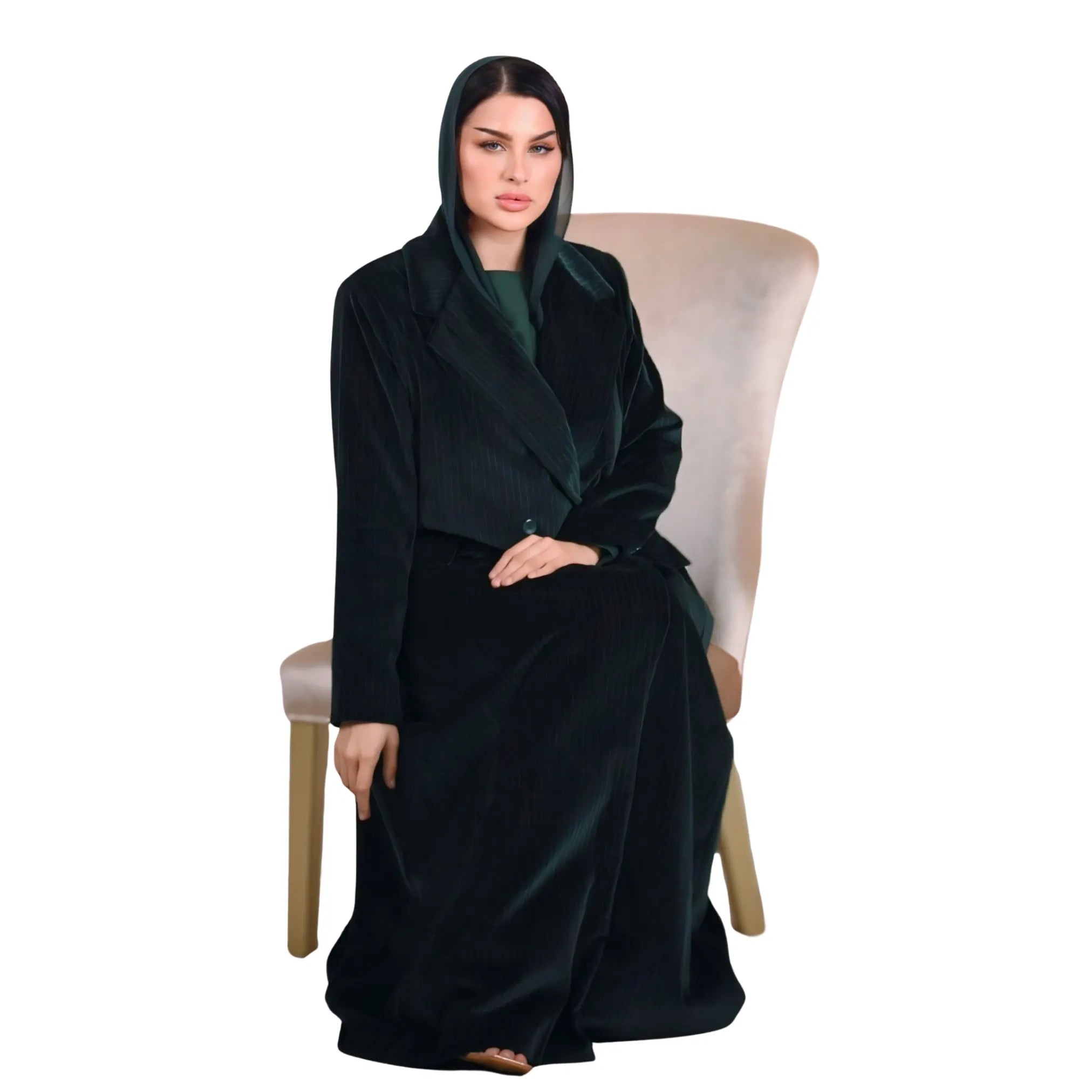 Woman wearing a Emerald Green abaya sitting on a chair with a white background