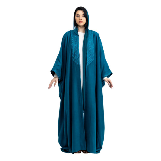 Woman wearing a teal abaya on a white background