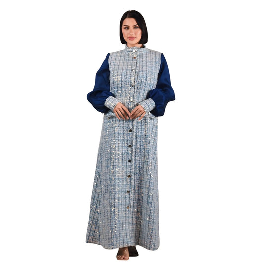 Woman wearing a long, plaid dress with a blue top on a white background