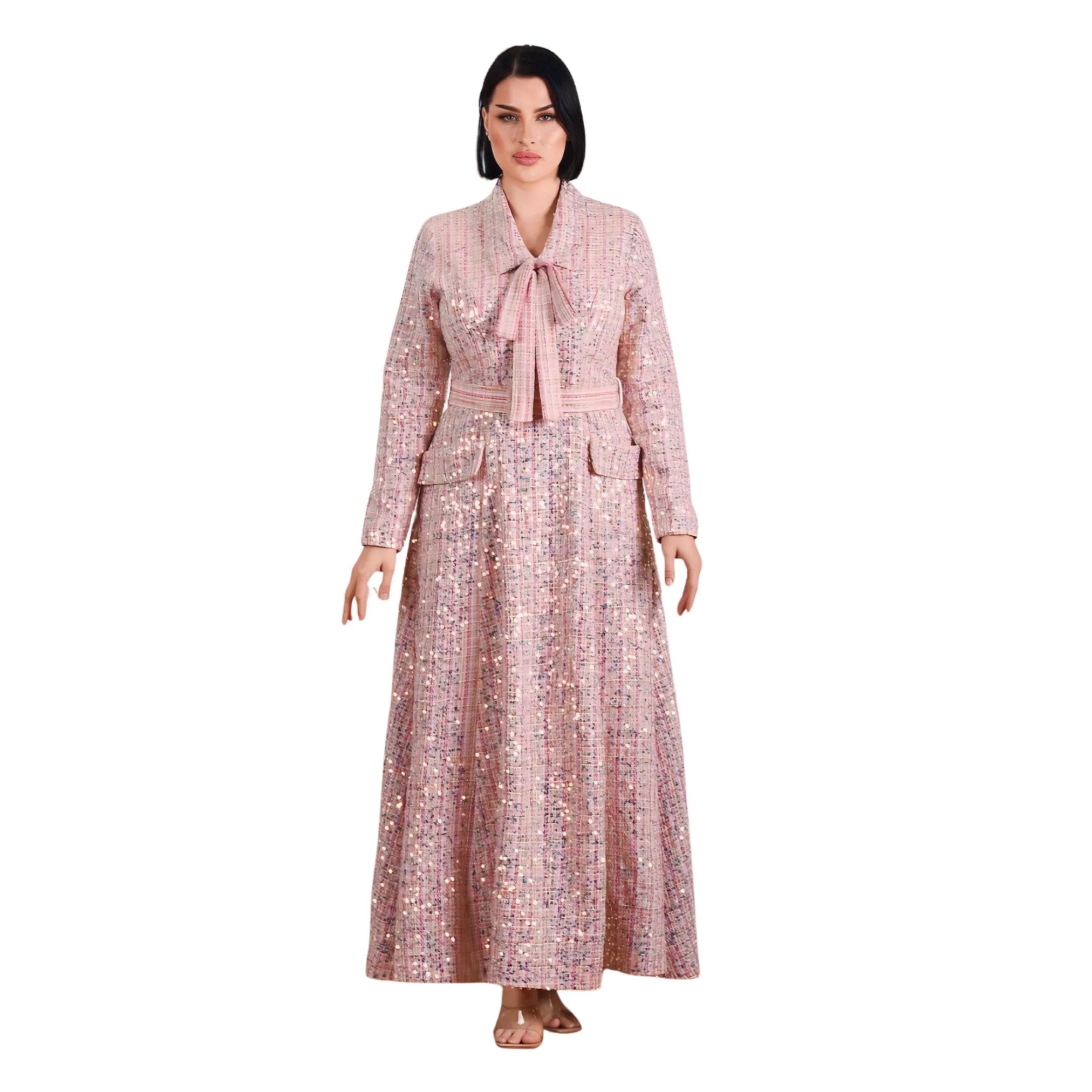 Woman wearing a long, patterned dress with a belt on a white background