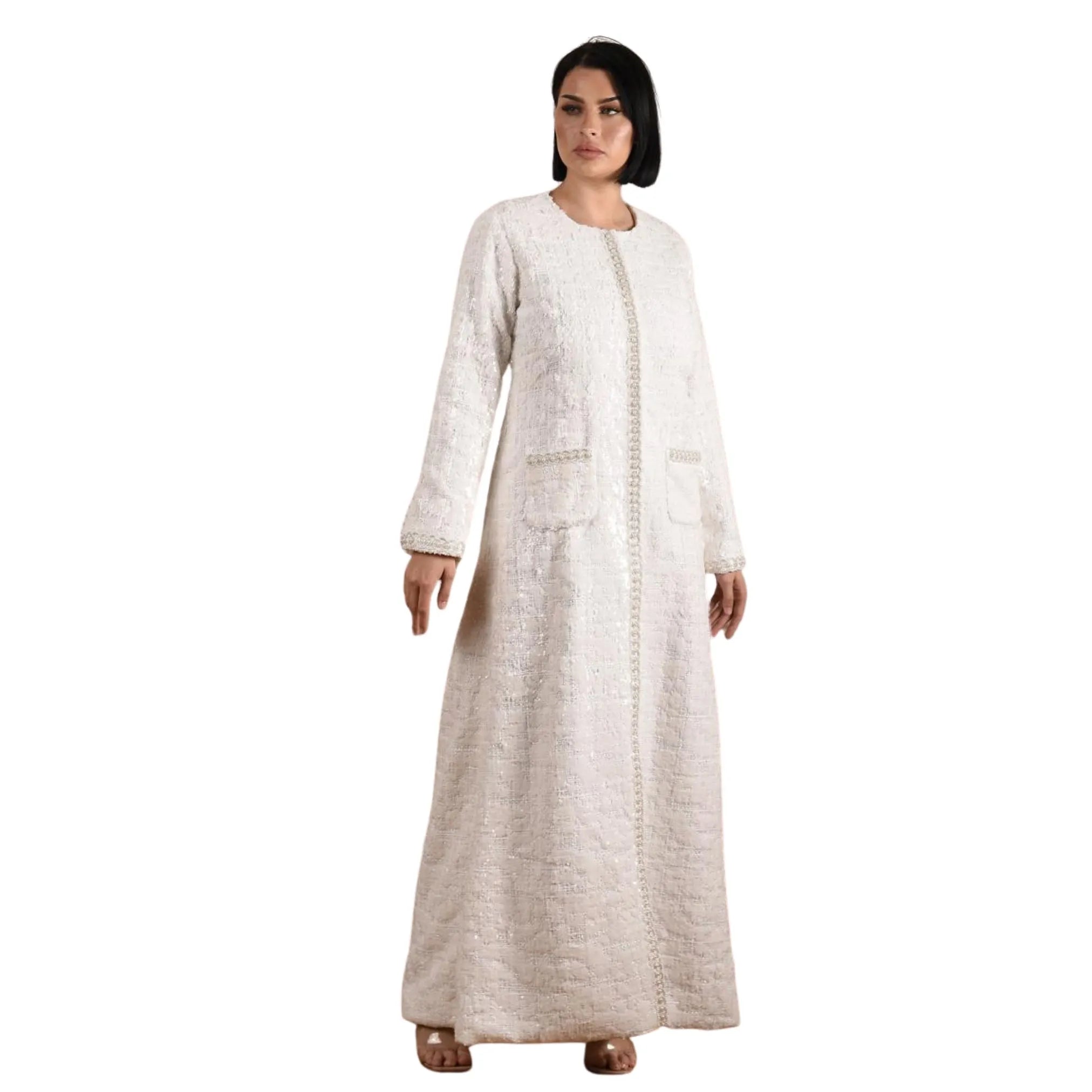 Woman wearing a long, light-colored dress with a textured pattern on a white background