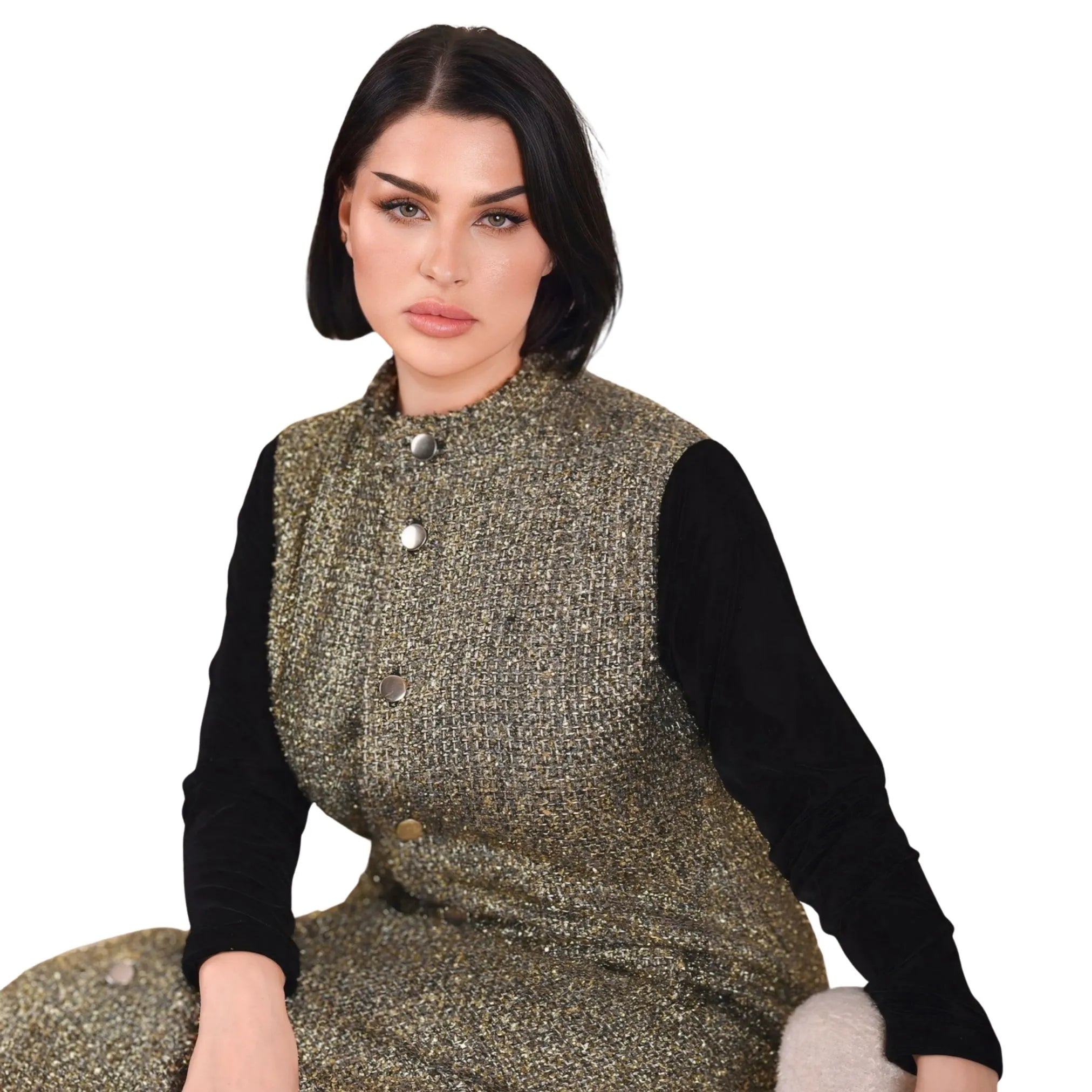 Woman wearing a patterned vest over a black shirt on a white background