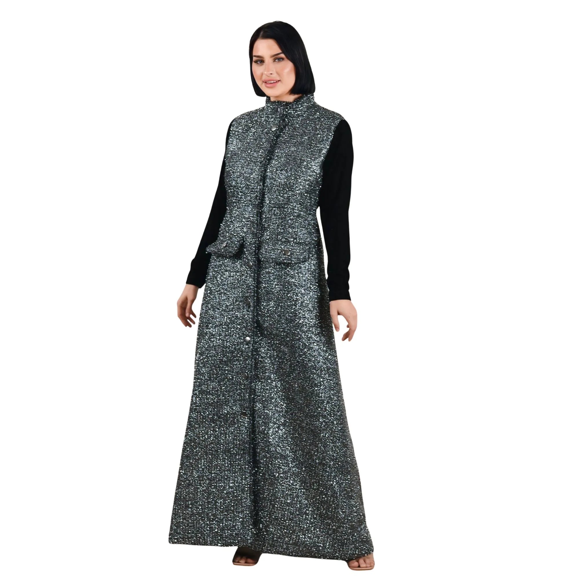 Woman wearing a long, dark gray patterned dress with a black top on a white background