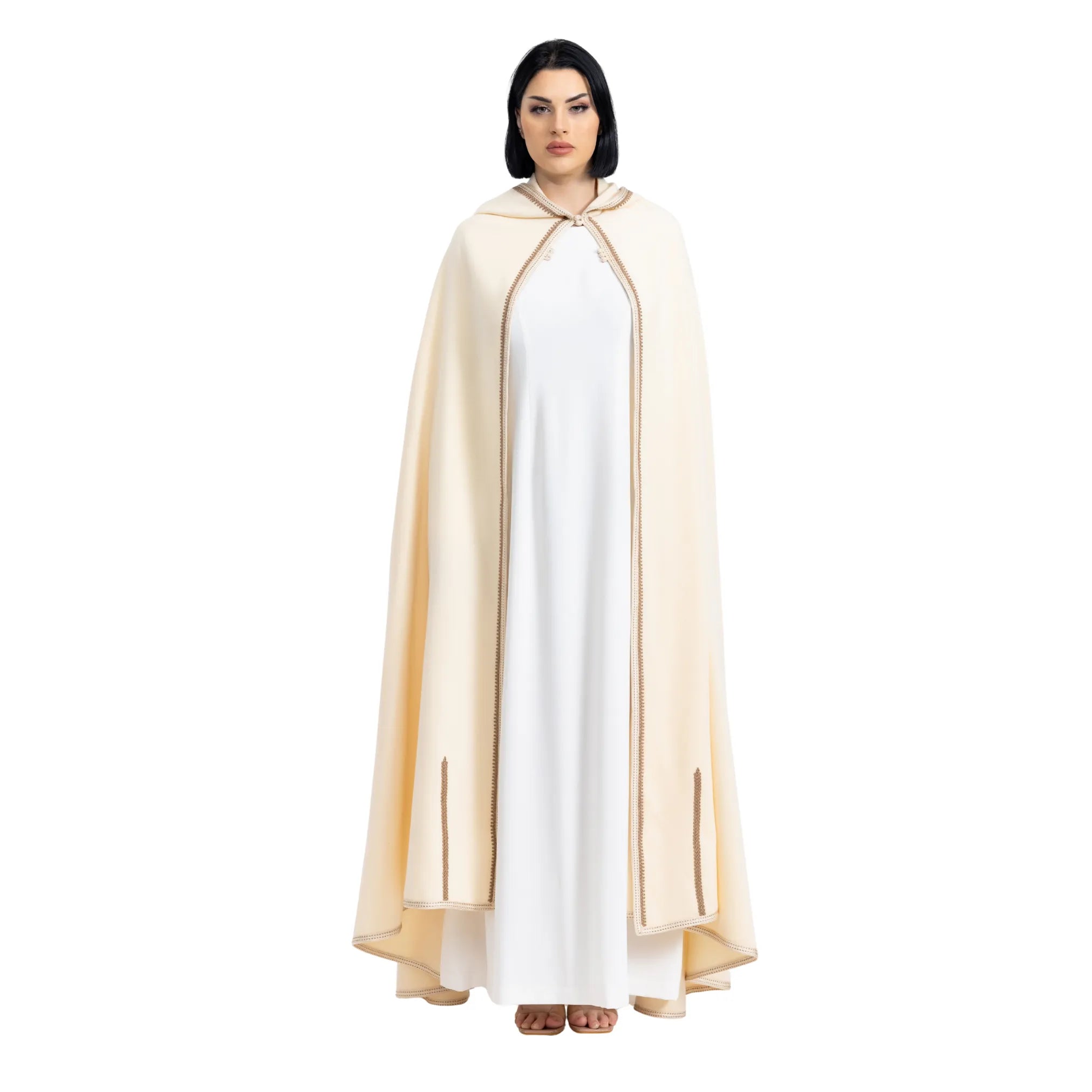 Person wearing a white dress with a beige cape on a white background