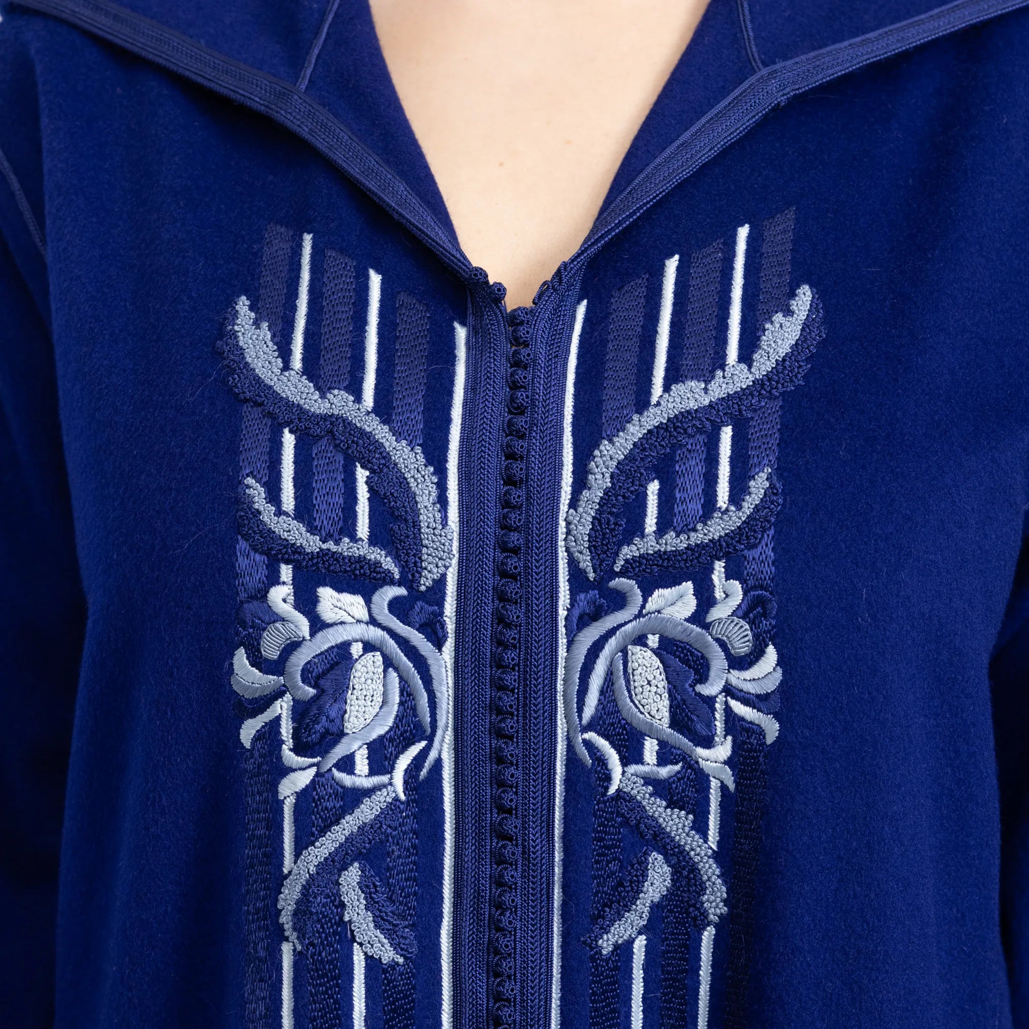 Navy blue jalabiya with intricate white floral embroidery on a zipper