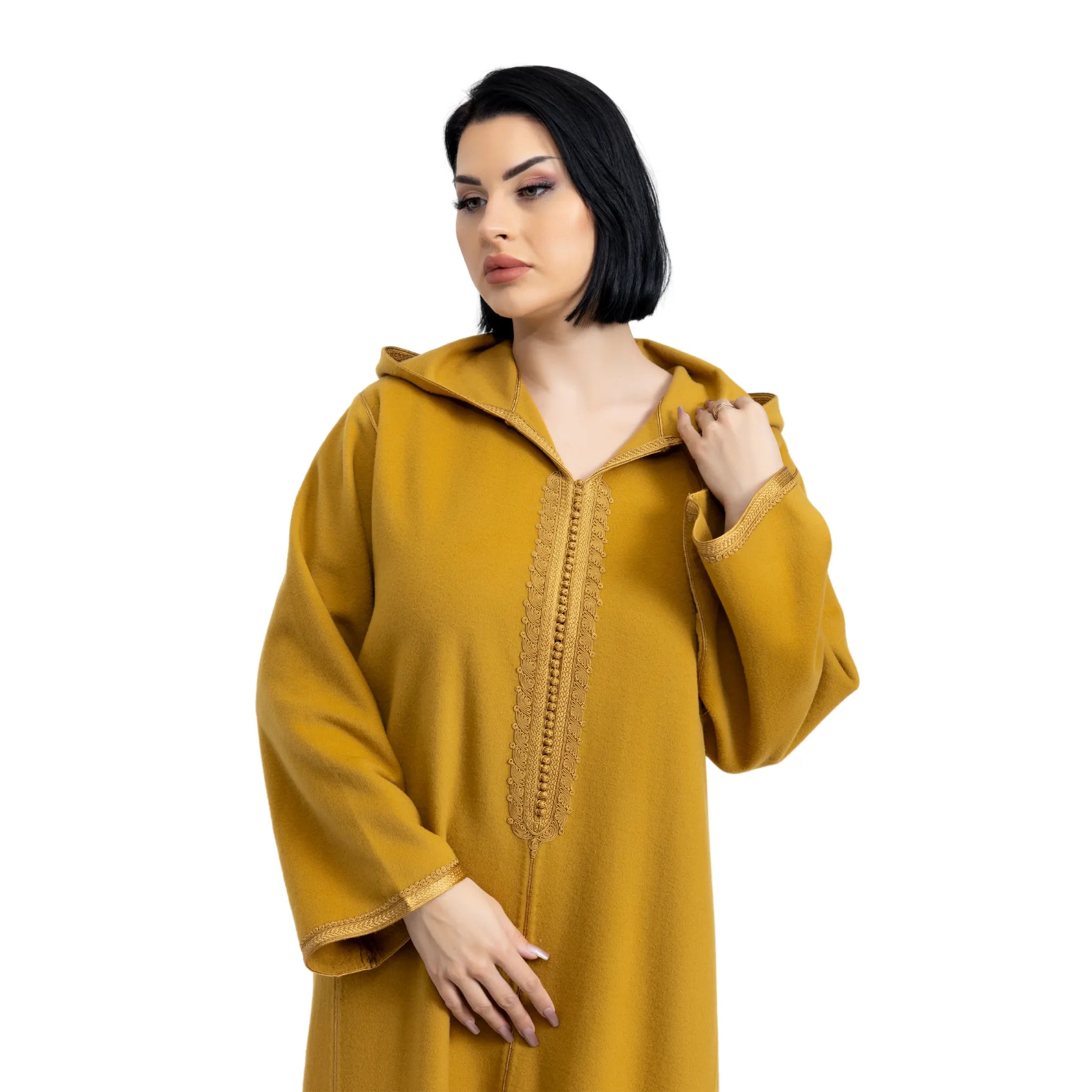 Woman wearing a mustard yellow jalabiya with lace details on a white background