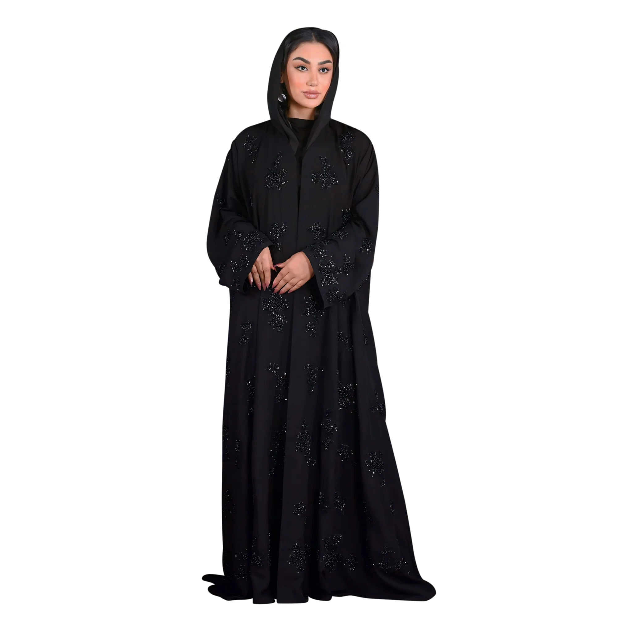 Woman wearing a black abaya with intricate designs on a white background