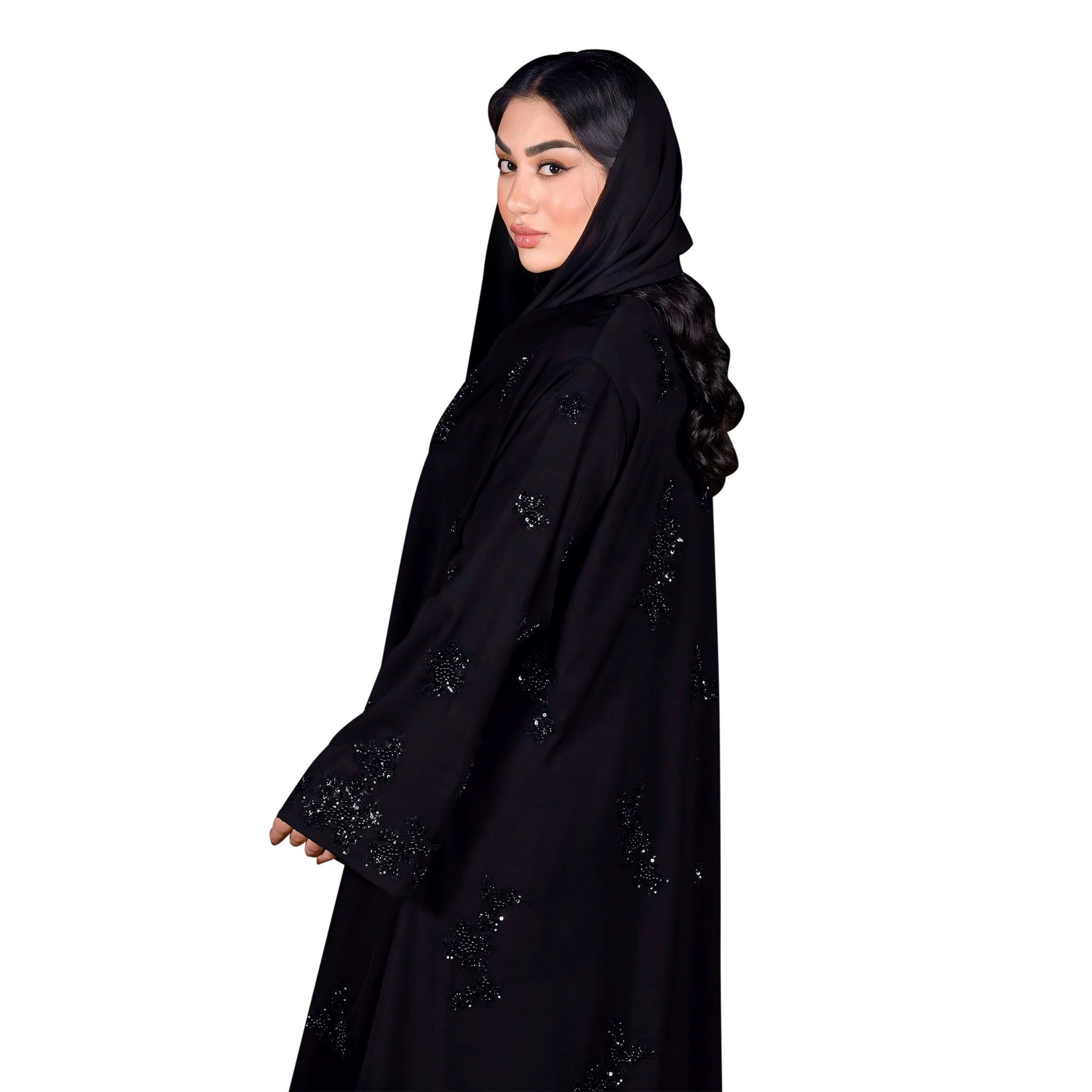 Woman wearing a black abaya with intricate designs on a white background