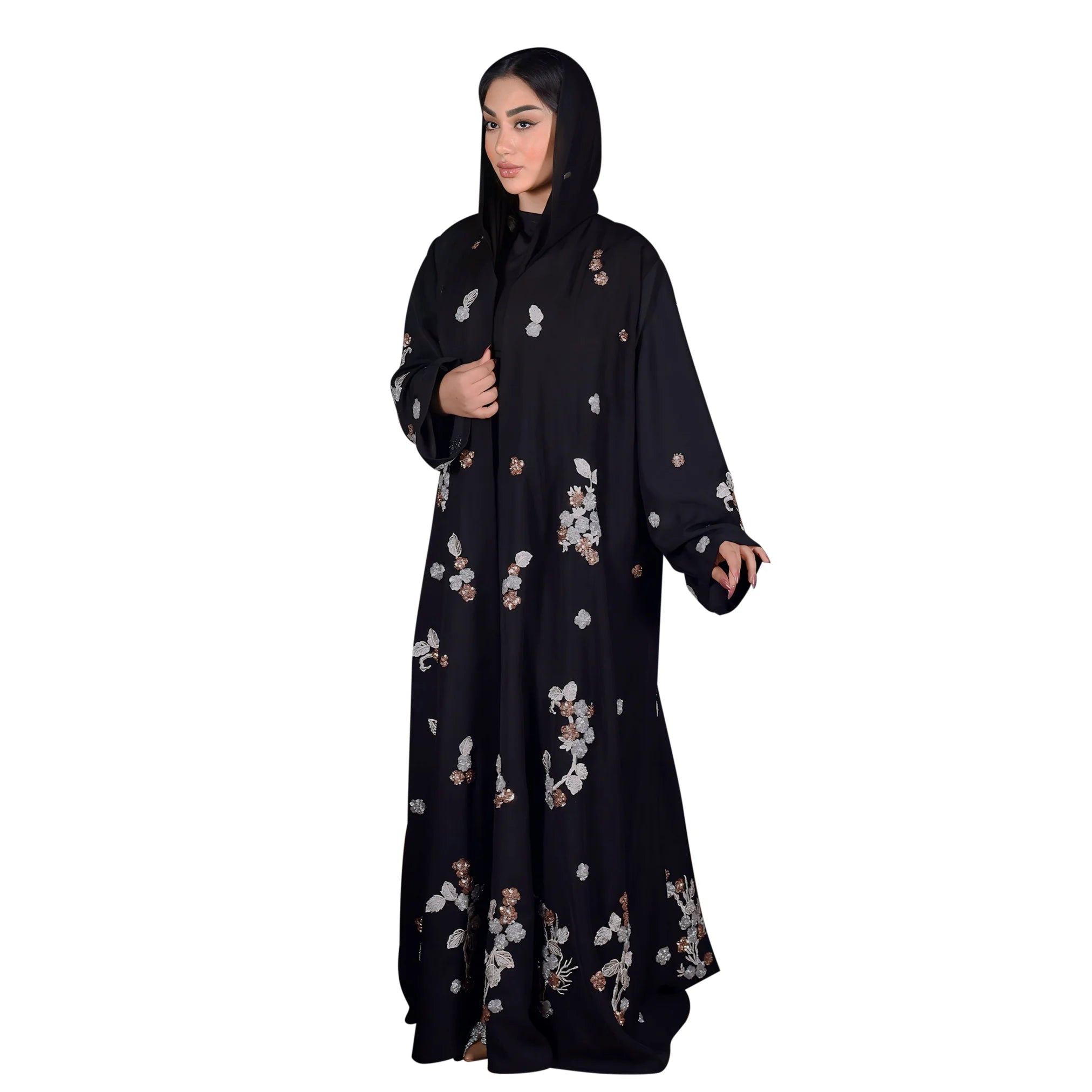 Woman wearing a black abaya with floral patterns on a white background