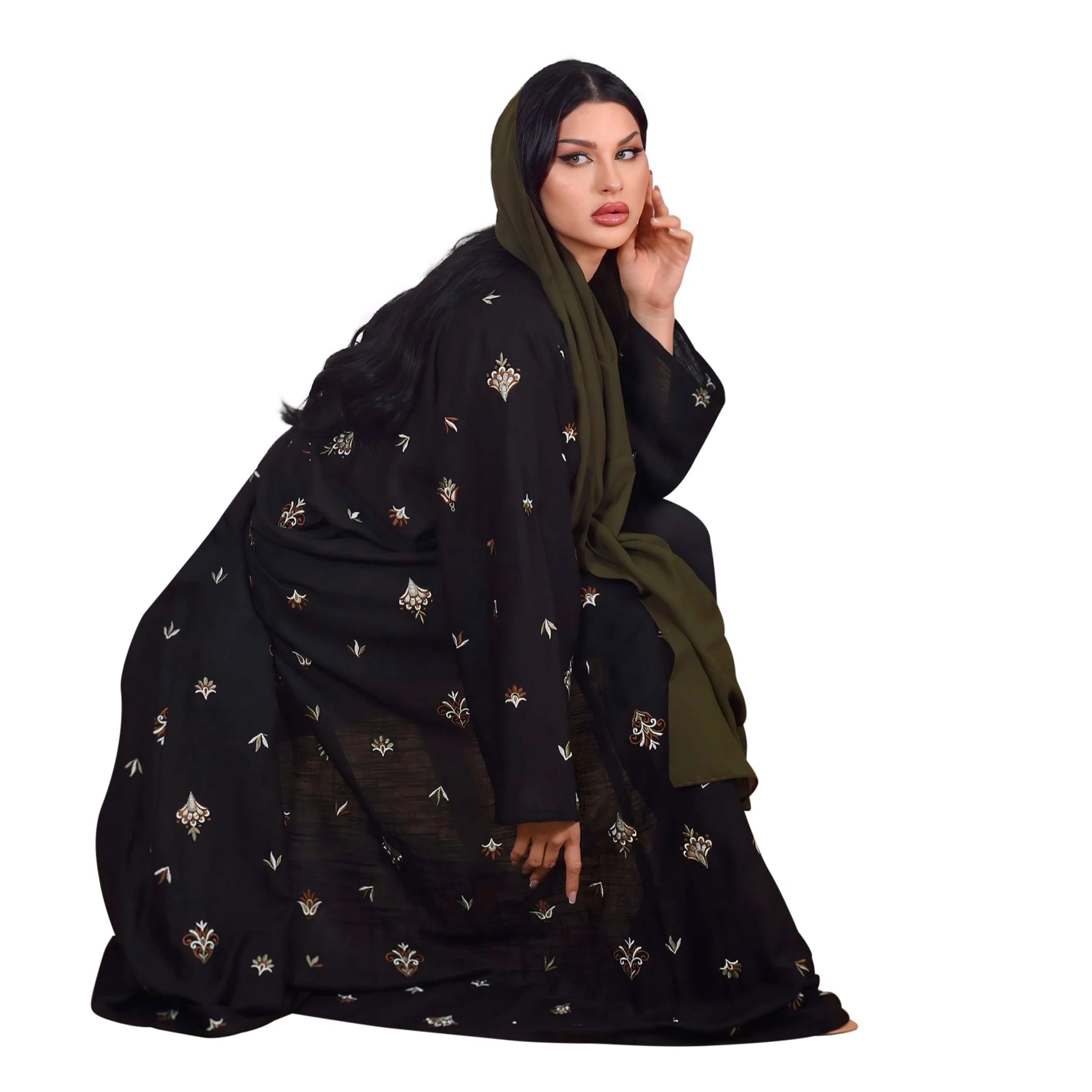 Woman wearing a black embroidered abaya with a green hood on a white background