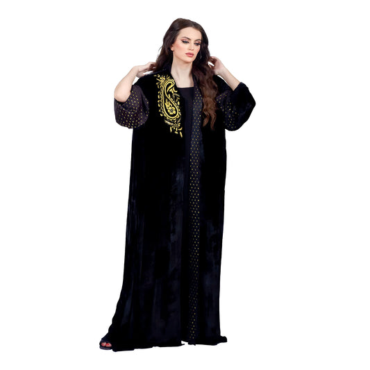 Woman wearing a black abaya with gold embroidery on a white background
