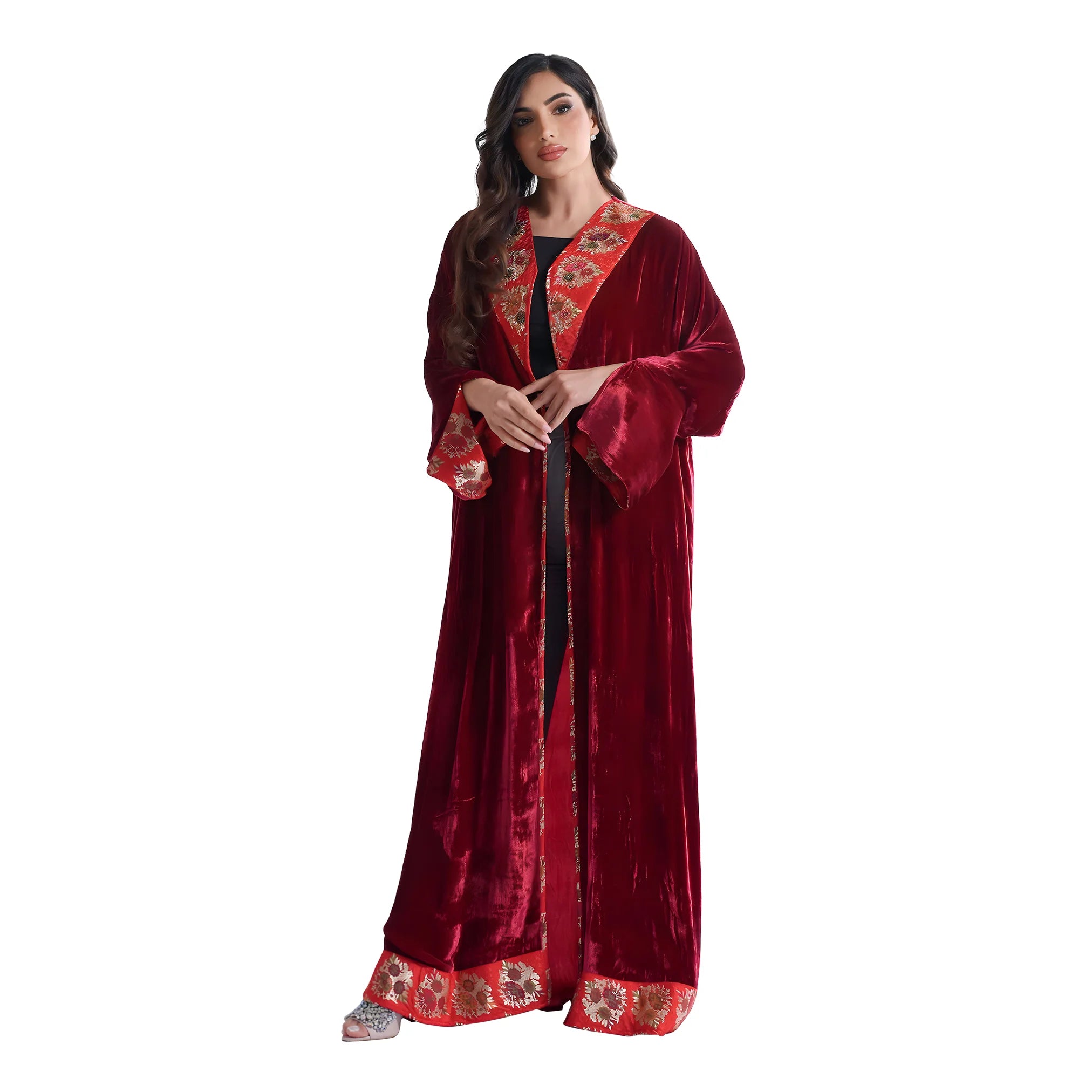 Woman wearing a red abaya with floral patterns on a white background