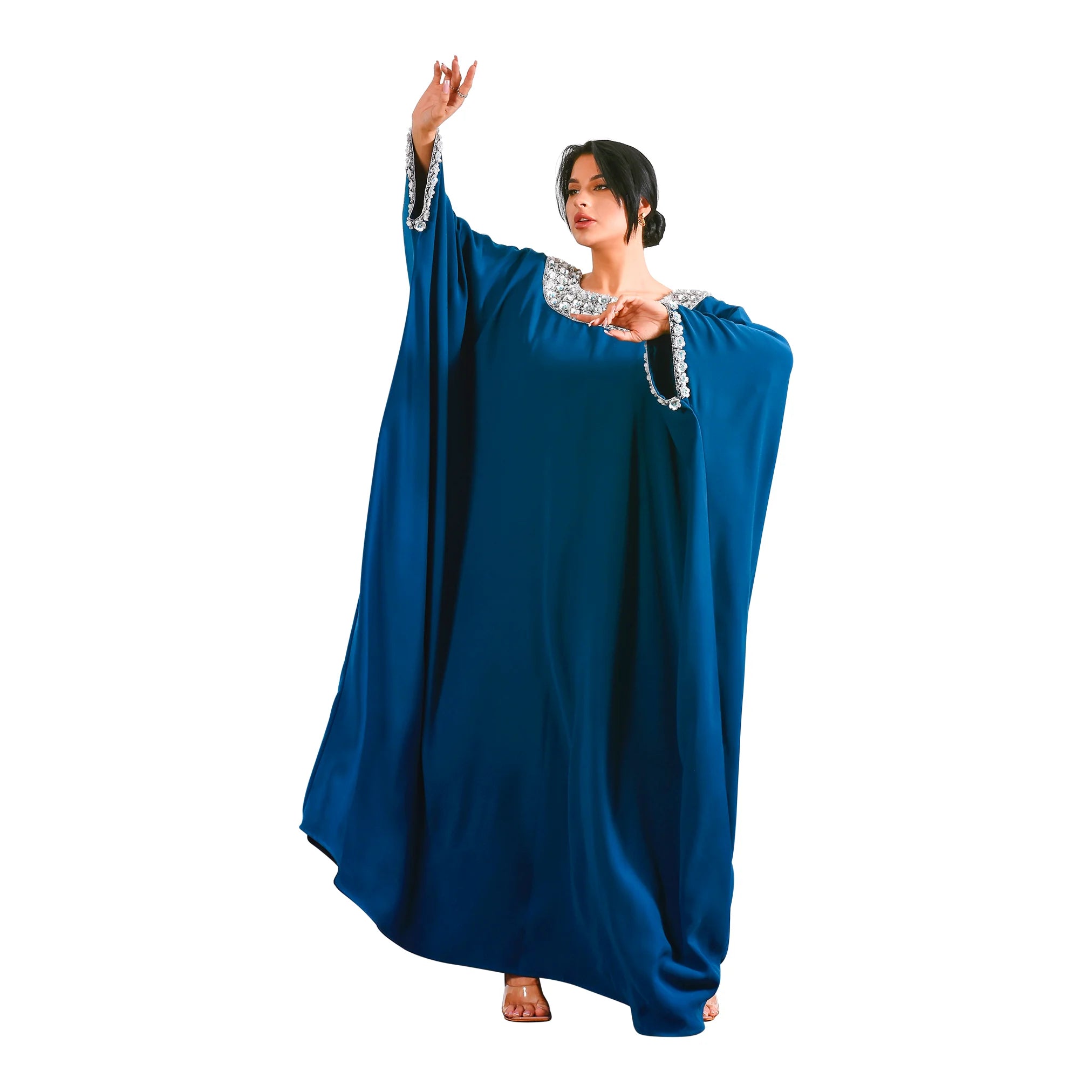 Woman wearing a blue dress with white embellishments on a white background