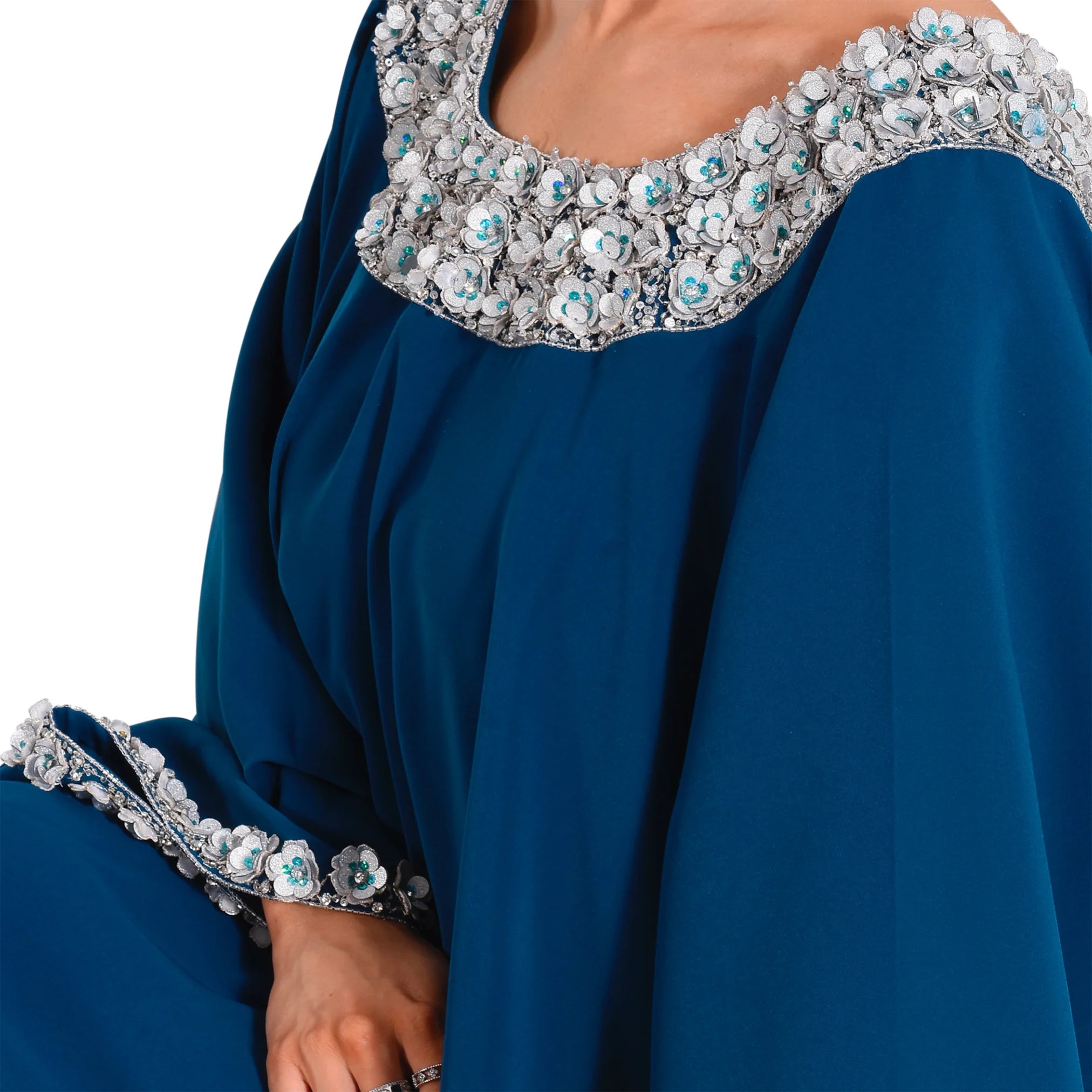 Blue dress with intricate silver and turquoise embellishments on a white background