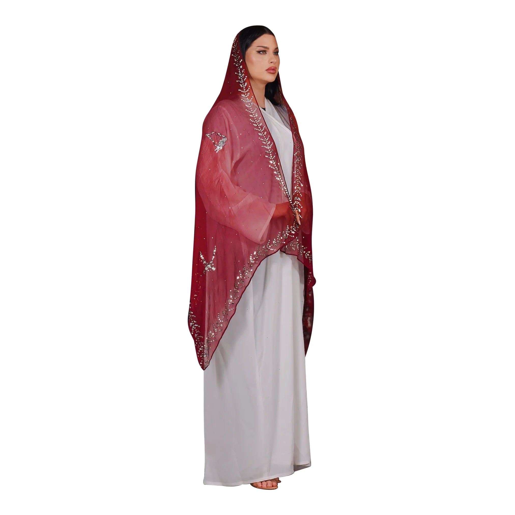 Woman wearing a red embroidered abaya and white dress on a white background