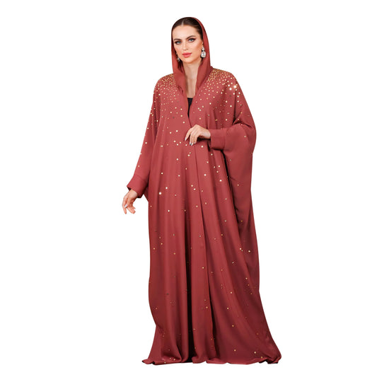 Woman wearing a red abaya with white patterns on a white background