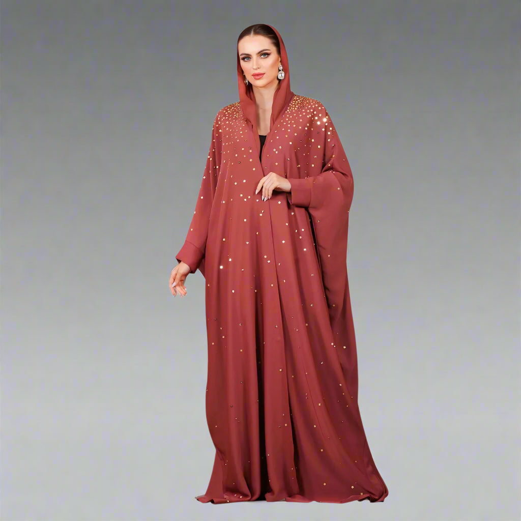 Red abaya with white patterns worn by a model on a white background