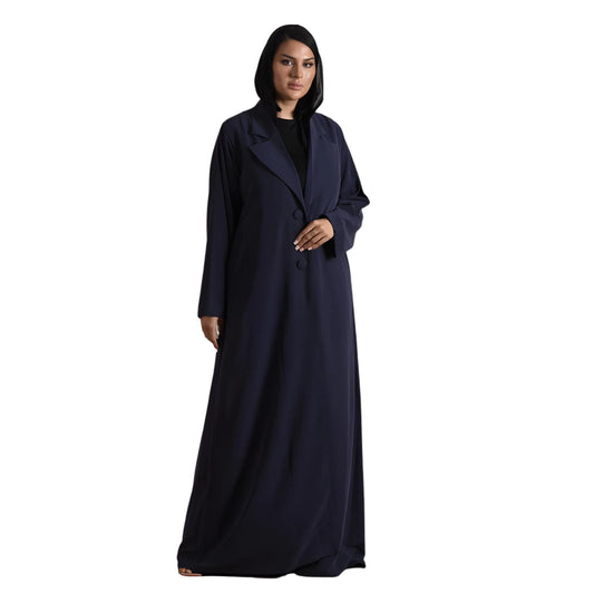 Woman wearing a long dark blue abaya on a white background
