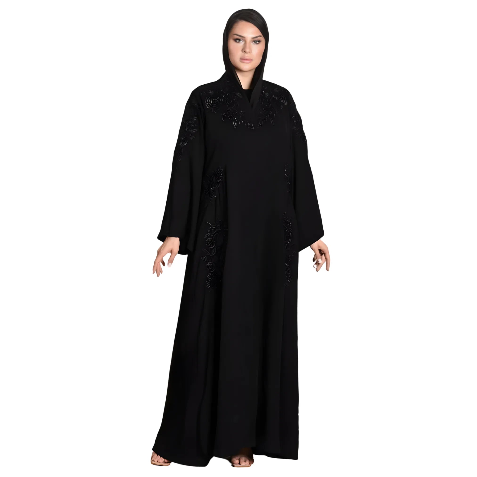 Woman wearing a black abaya with intricate detailing on a white background