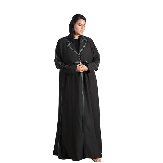 Woman wearing a black abaya with white trim on a white background