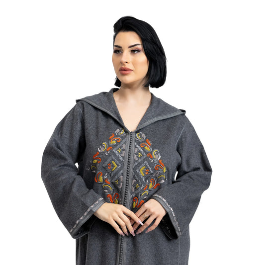 Woman wearing a gray hooded jalabiya with colorful embroidery on a white background