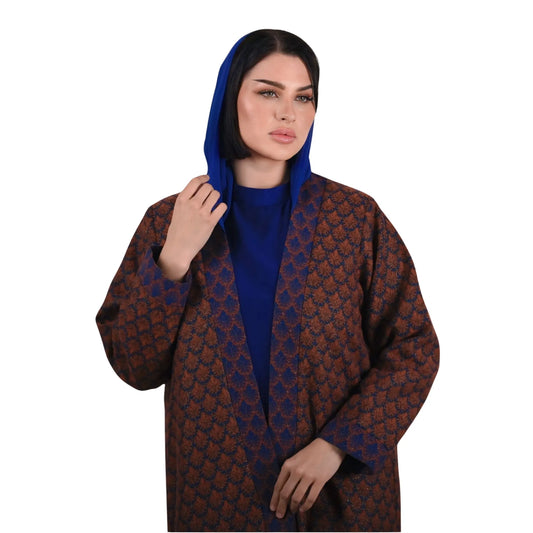 Woman wearing a patterned brown and blue abaya on a white background
