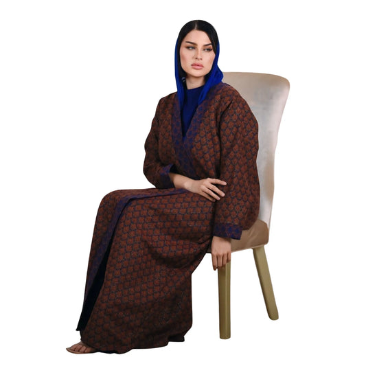 Woman wearing a patterned abaya sitting on a chair against a white background