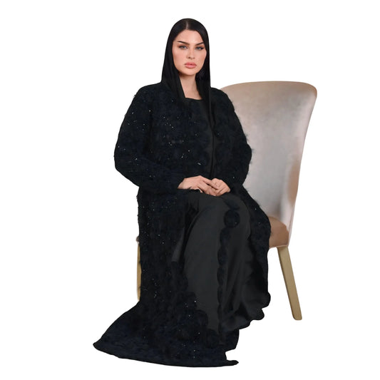 Woman wearing a black abaya sitting on a chair with a white background