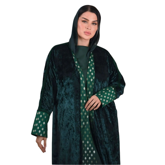 Woman wearing a green and black patterned abaya on a white background