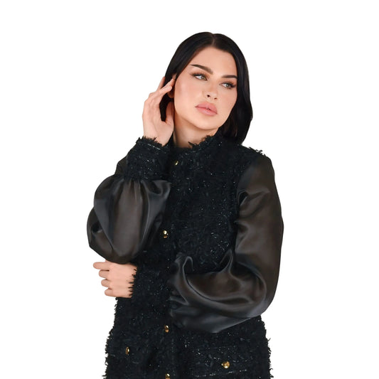 Woman wearing a black textured jacket on a white background