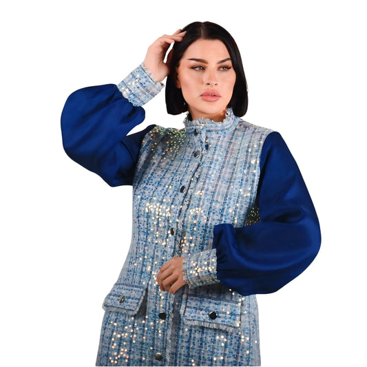 Woman wearing a blue and silver sequin jacket on a white background