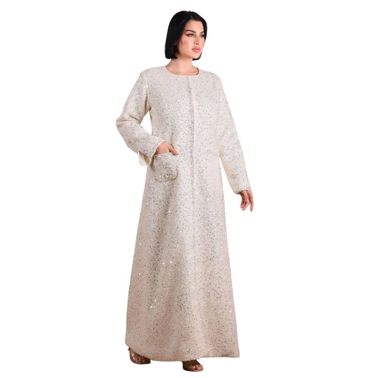 Woman wearing a long, light-colored dress with a subtle pattern on a white background