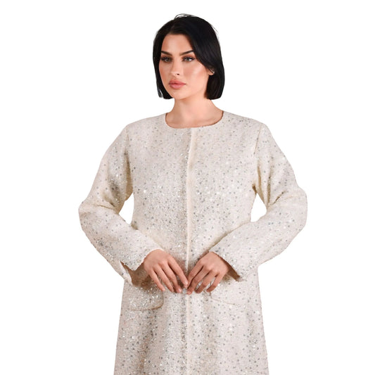 Woman wearing a long, light-colored coat on a white background