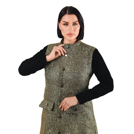 Woman wearing a metallic green vest over a black long-sleeve shirt on a white background