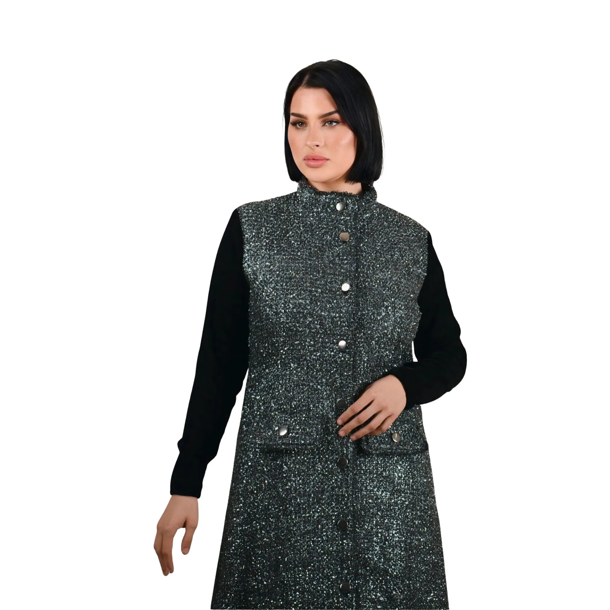 Woman wearing a black and gray patterned vest over a black long-sleeve shirt on a white background