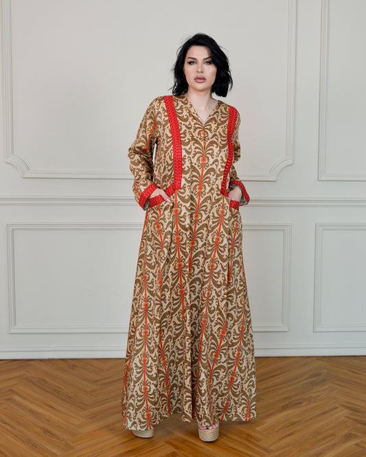 جلابية منقوشة بتطريزات حمراء في الأمام والأكمام، مع جيوب أمامية.