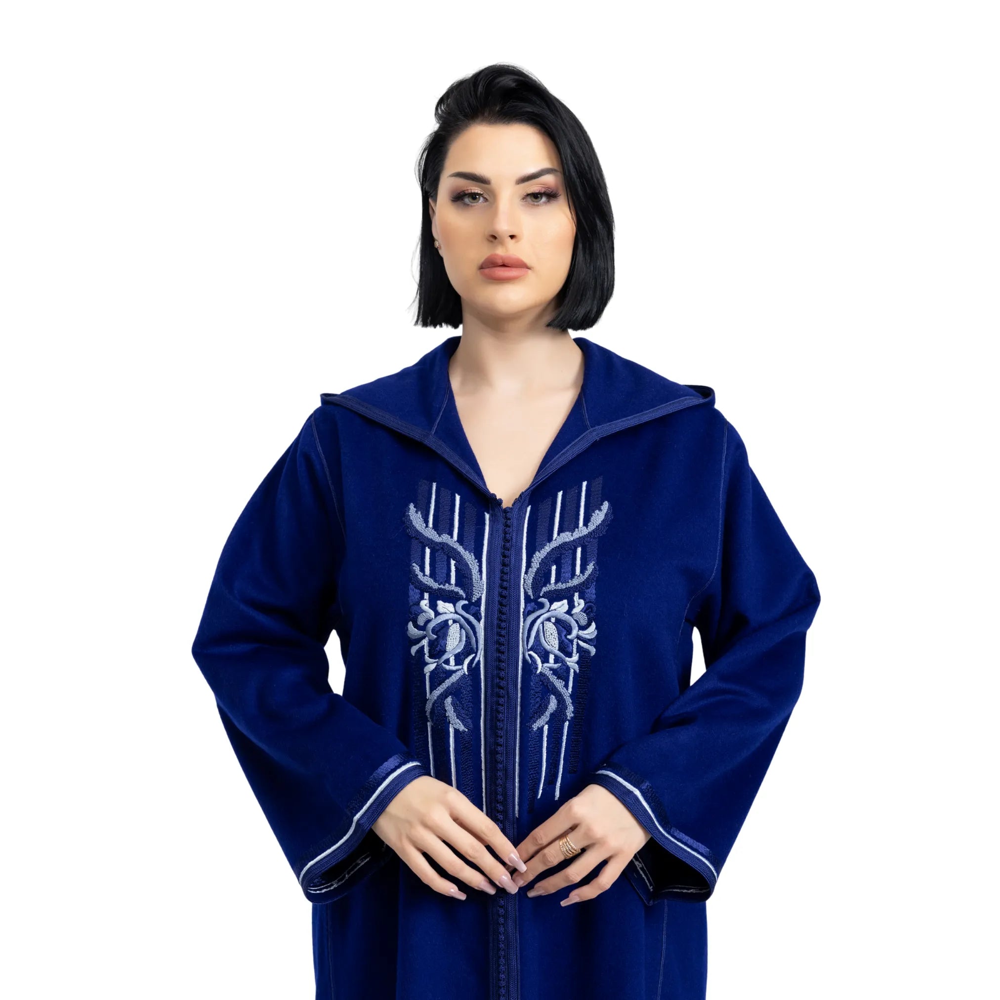 Woman wearing a blue jalabiya with white embroidery on a white background