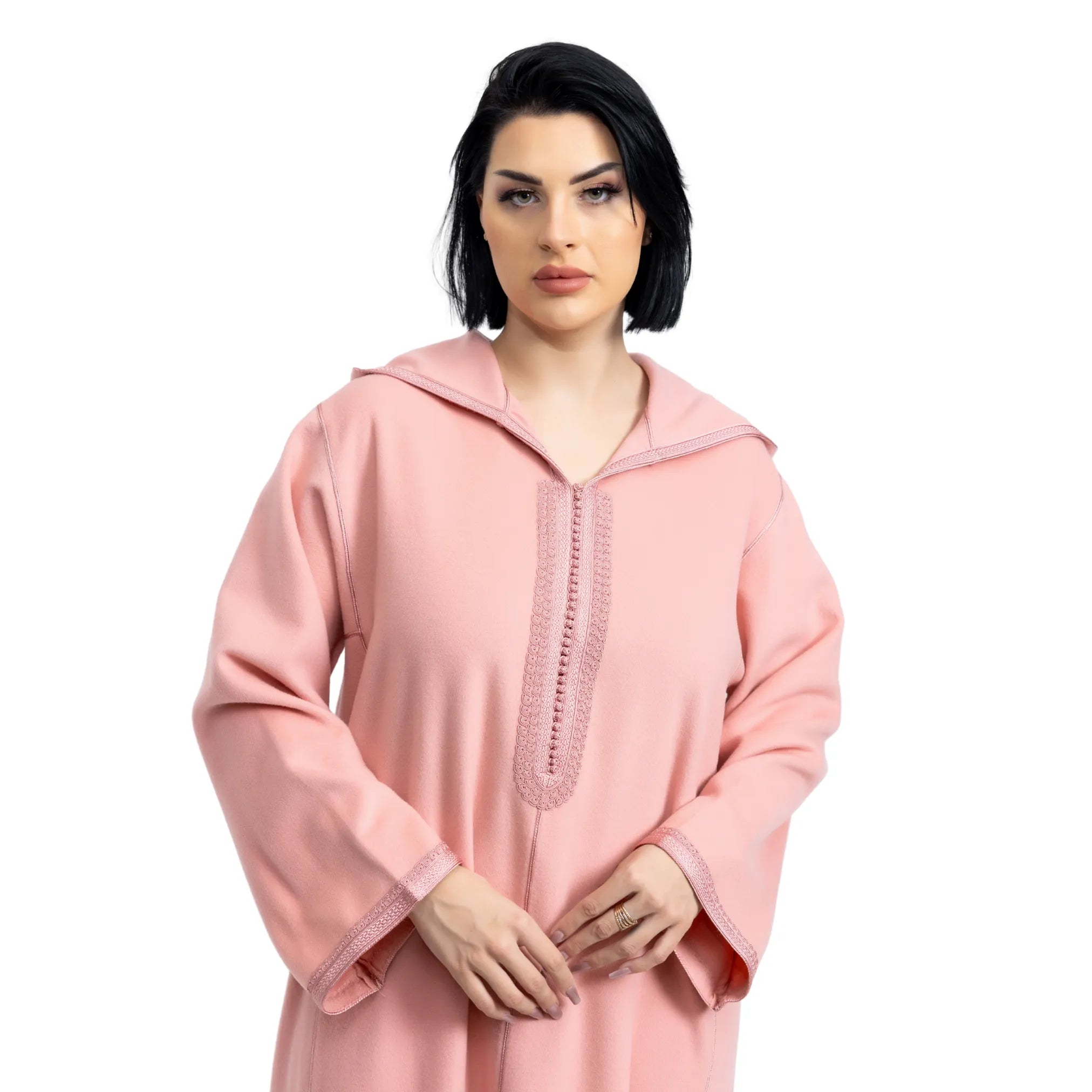 Woman wearing a pink jalabiya with lace details on a white background