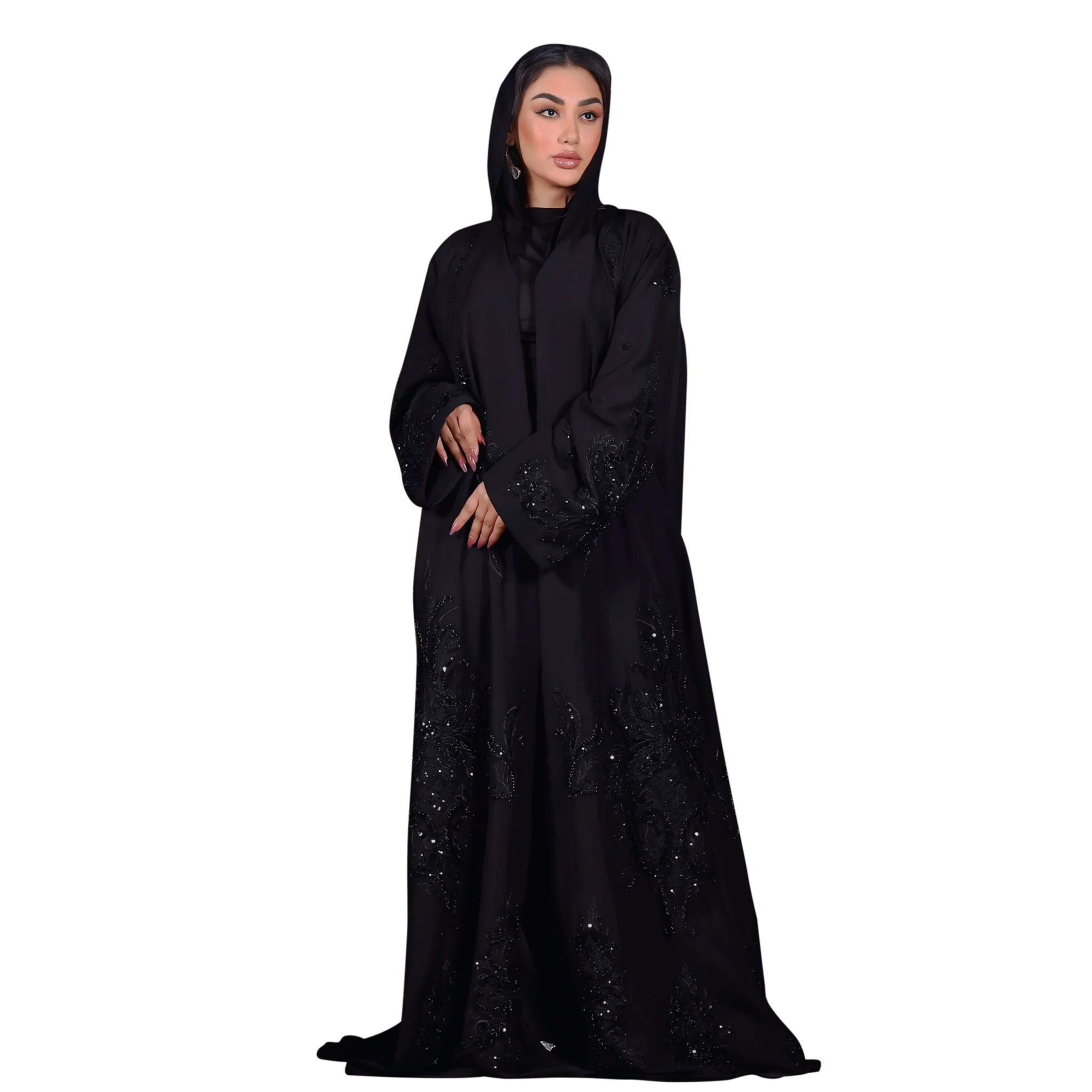 Woman wearing a black abaya with intricate designs on a white background