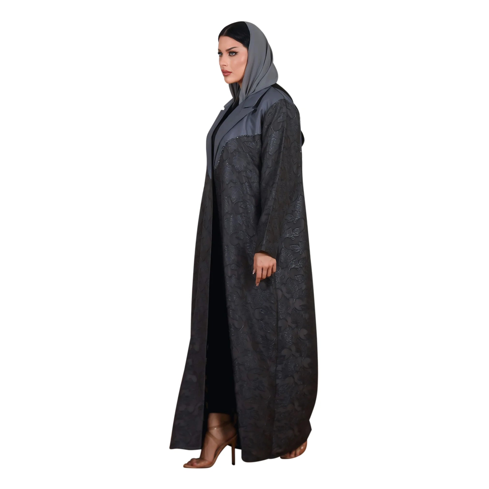 Woman wearing a long dark gray abaya with a hood on a white background