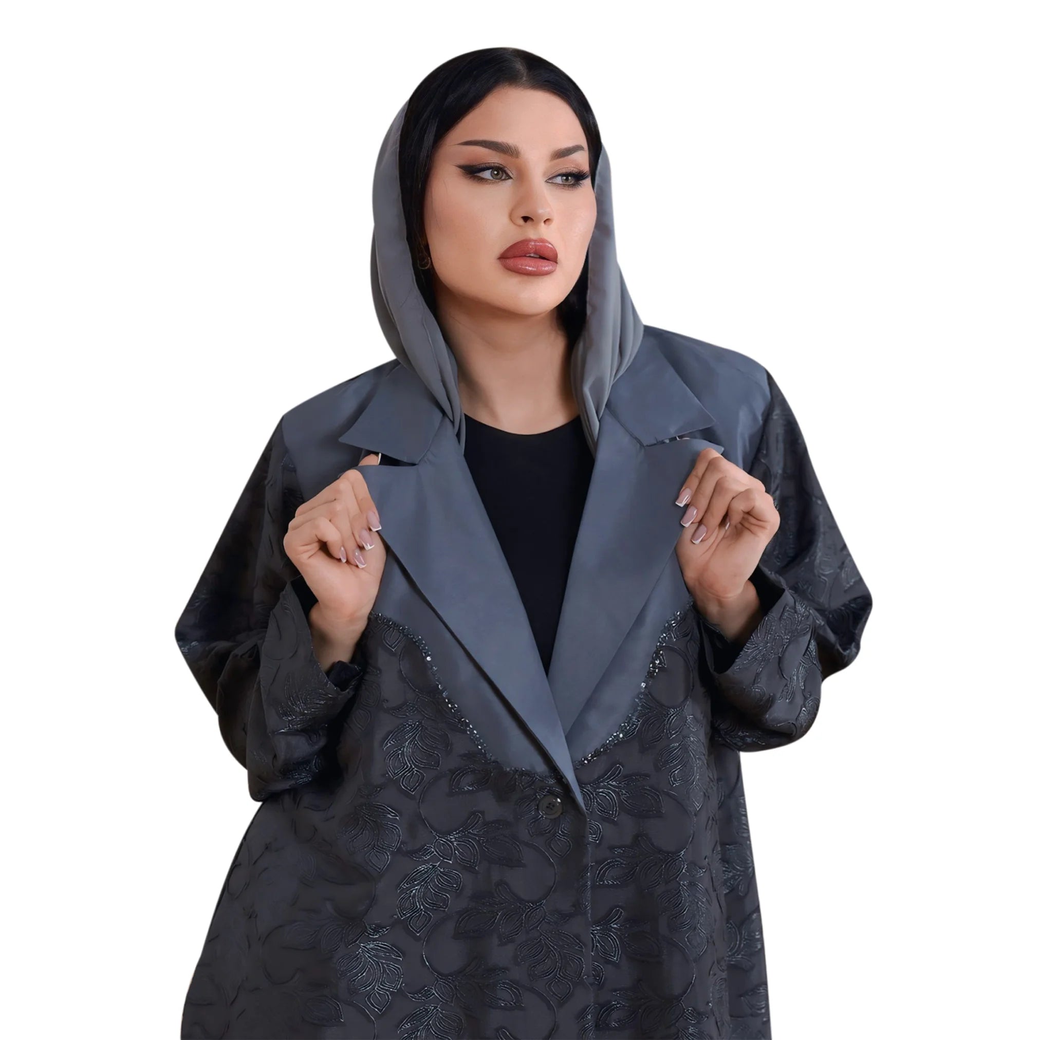 Woman wearing a dark gray abaya with floral patterns on a white background