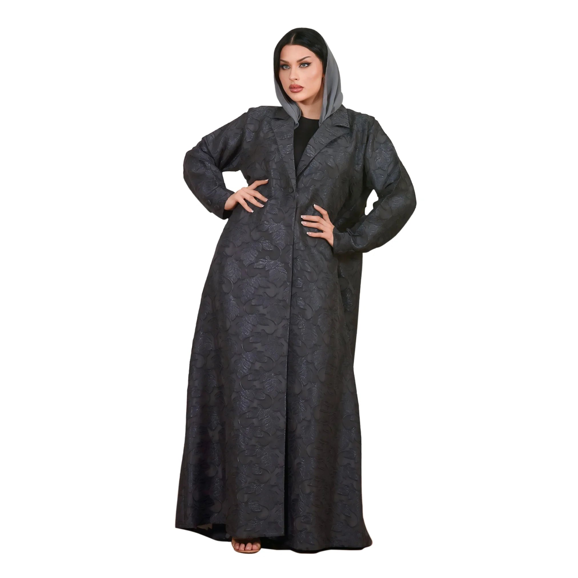 Woman wearing a long dark gray abaya with a hood on a white background